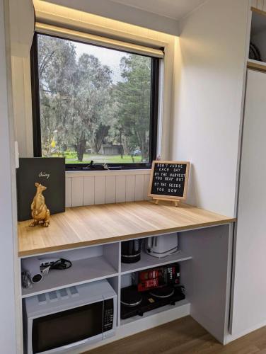 a kitchen with a counter and a window at Tiny Homes Escape at Grampians Edge by Tiny Away in Dadswells Bridge