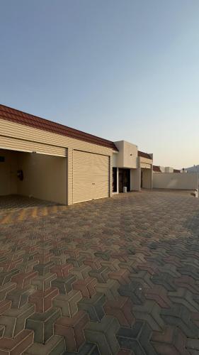 a large brick parking lot with two buildings at شاليهات رميس للعائلات in Abha