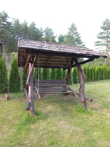 a wooden bench with a gazebo in a field at Holiday home Family in Alajõe