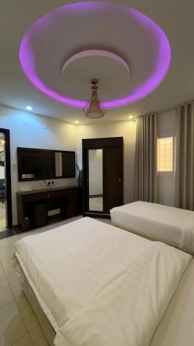 a bedroom with two beds and a purple ceiling at شاليهات رميس للعائلات in Abha