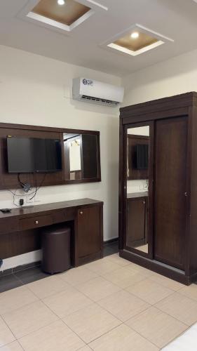 a room with a desk with a television and a mirror at شاليهات رميس للعائلات in Abha