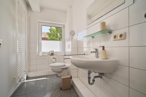 マルヒョーにあるFerienwohnung Seehus - Modernes Ferienhaus mit Sauna, Seezugang und Bootsanlegeplatzの洗面台とトイレを備えた白いバスルーム
