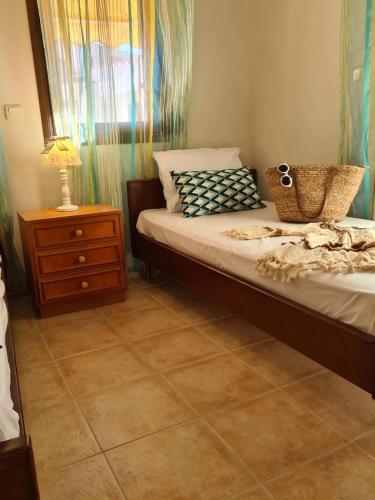 a bedroom with a bed with a dresser and a window at Andreadis maissonette in Skala Potamias