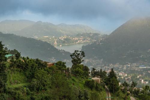 a view of a town on a hill with a lake at Hotel Sun Ray Inn in Bhowāli