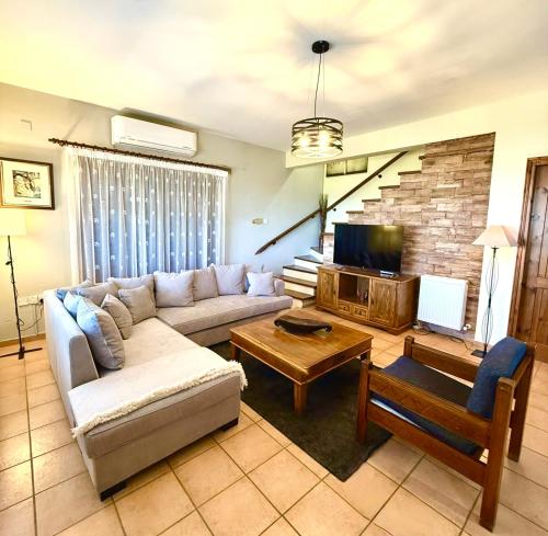 a living room with a couch and a tv at Apokas Country House in Zoopiyi
