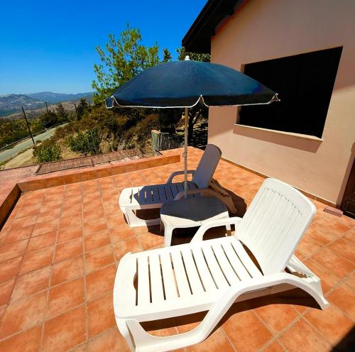 two chairs and an umbrella on a patio at Apokas Country House in Zoopiyi