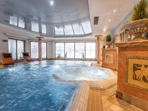 a large swimming pool in a large room at Der Lärchenhof in Erpfendorf