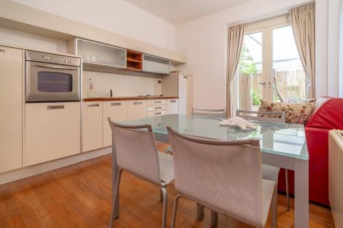 a kitchen with a table and chairs and a couch at Verdeluna ApartHotel in Marina di Pietrasanta