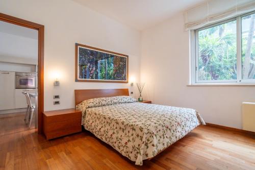a bedroom with a bed and a large window at Verdeluna ApartHotel in Marina di Pietrasanta