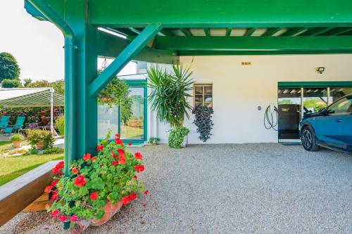 a garage with a green pergola and flowers at Gure Xokoa in Urrugne