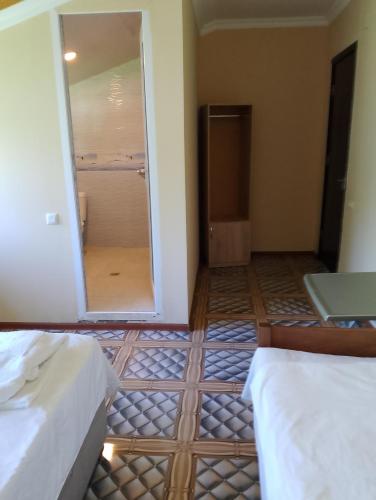 a room with two beds and a door to a bathroom at New Wave1 in Grigoleti