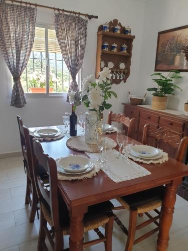 a dining room with a wooden table with chairs at La casa de mis padres in Júzcar