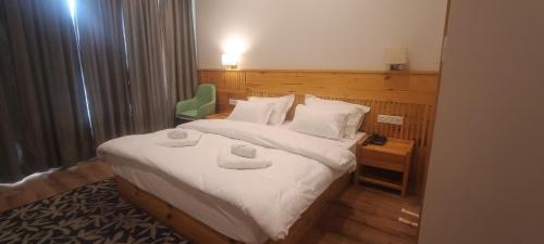 Una habitación de hotel con una cama con dos toallas encima. en Sintik Residency, en Leh