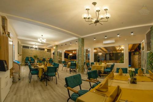 a restaurant with tables and chairs and a chandelier at Villa&Restaurant Strmec in Elshani