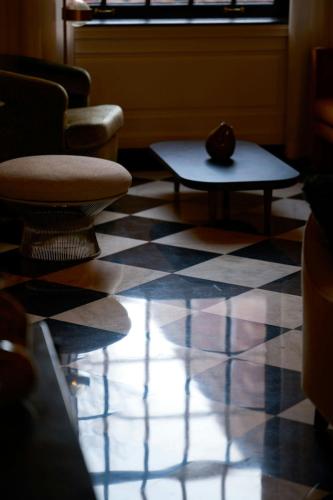 a room with a checkered floor with chairs and a cat on a table at Dearborn Inn, Autograph Collection in Dearborn