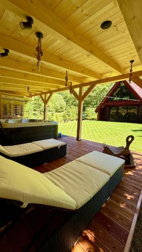 due letti su una terrazza di legno sotto un tetto di legno di PARADiSE Wellness Chalet - Sauna&SPA a Belá
