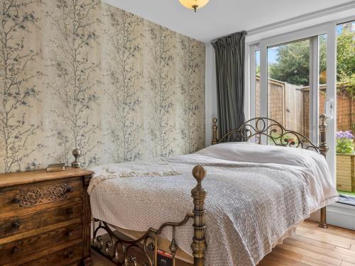 a bedroom with a bed with a dresser and a window at Pass the Keys Bright Town-Centre Flat with Outdoor Area in Ulverston