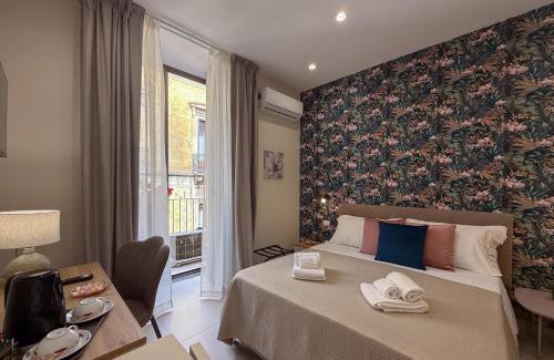 カターニアにあるTown House 54の花の壁のベッドルーム1室(大型ベッド1台付)