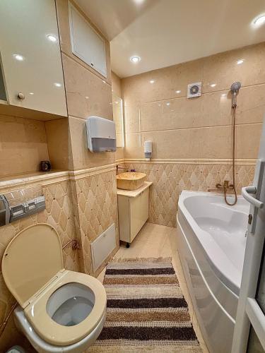 a bathroom with a toilet and a tub and a sink at Apartament de lux cu terasă in Ploieşti