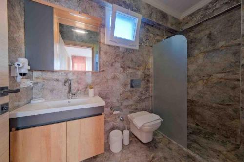 un baño con lavabo e inodoro en Yaz Villa 2, en Fethiye