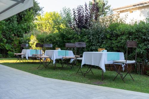a group of tables and chairs sitting in the grass at Verdeluna ApartHotel in Marina di Pietrasanta