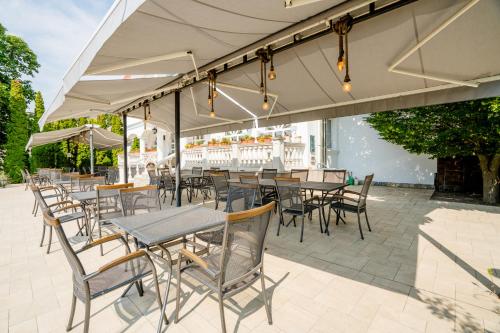 an outdoor patio with tables and chairs under a tent at Prémium Panzió Miskolctapolca in Miskolctapolca