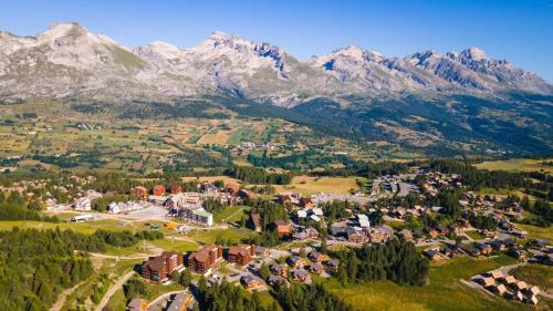 an aerial view of a town with mountains in the background at Superdevoluy appart 7ème étage sud Aurouze in Superdevoluy