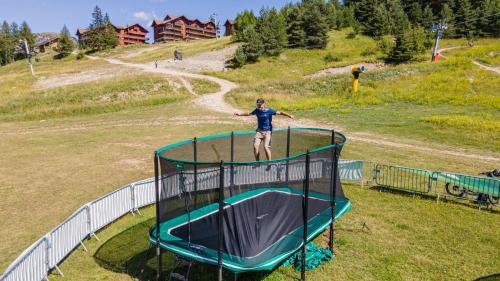 a man standing on top of a trampoline at Superdevoluy appart 7ème étage sud Aurouze in Superdevoluy