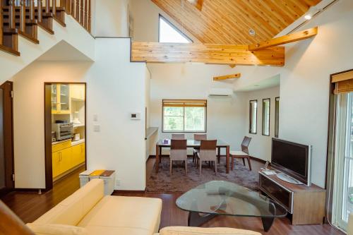 a living room with a couch and a table at 箱根 森の風を感じる一軒家 in Hakone