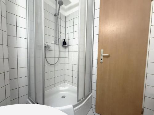 a shower with a glass door in a bathroom at DAS SCHMÖCKWITZ in Berlin