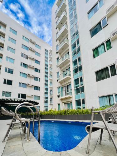 a pool with two chairs and a table and two buildings at 45 Neutral Style Studio for 3 in Iloilo City