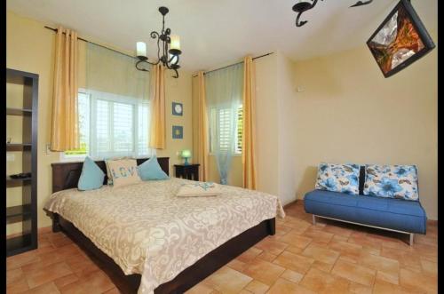 a bedroom with a bed and a blue couch at מול כנרת בליבנים in Livnim