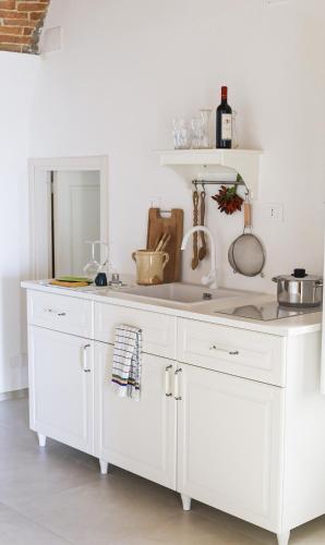 a white kitchen with a white counter top at Palazzo Ammicc in Bernalda