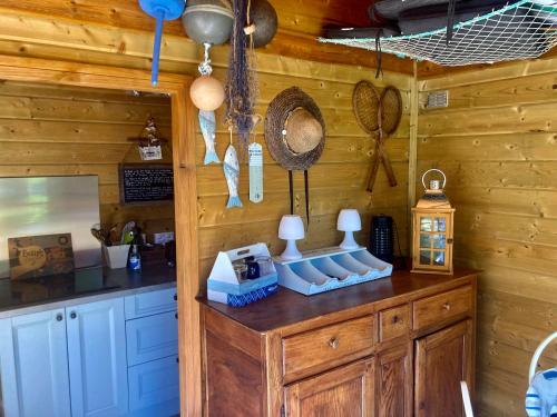 - une cuisine avec des murs en bois et un comptoir avec des ustensiles dans l'établissement Goh Lenn d'Er Ria, à Locoal