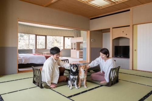 two people and a dog in a room at Wan Wan Paradise Hamanako in Hamamatsu