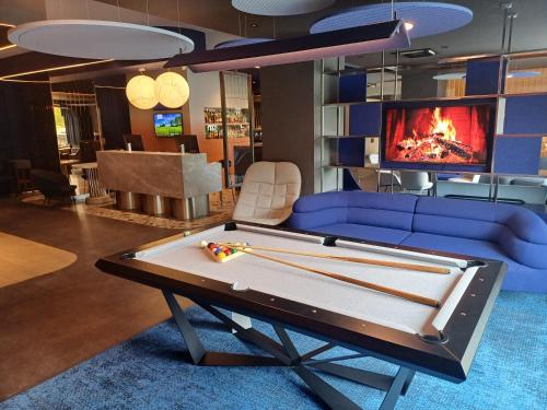 a living room with a pool table and a tv at Desilva Inn Katowice Airport in Pyrzowice