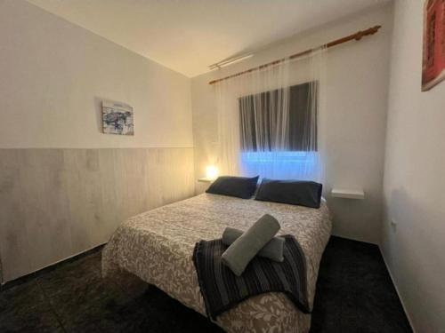 a bedroom with a bed with two pillows and a window at Terrazas del Sur in Los Abrigos