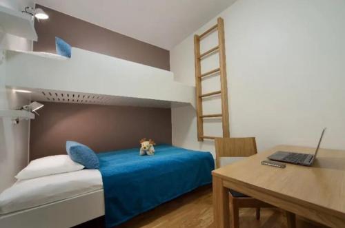 a bedroom with a bunk bed and a desk with a laptop at Ruka Ski Chalets, Ski-In Ski-Out in Ruka