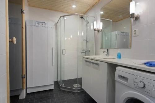 a bathroom with a shower and a washing machine at Ruka Ski Chalets, Ski-In Ski-Out in Ruka