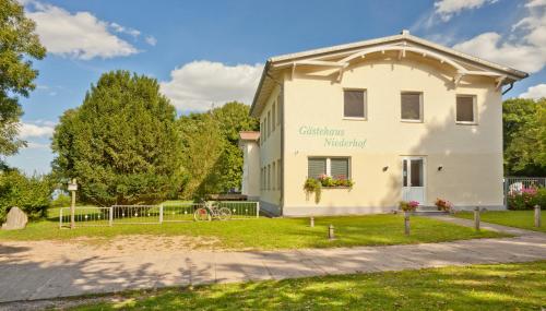 a white building with a sign on the side of it at Gästehaus Niederhof in Sundhagen