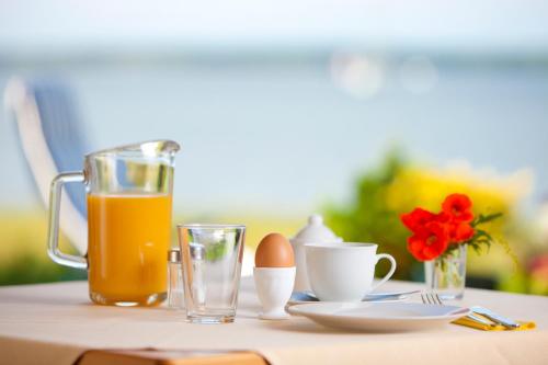 uma mesa com um copo de sumo de laranja e ovos em Gästehaus Niederhof em Sundhagen-Niederhof