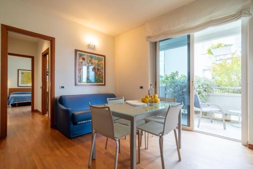 a dining room with a table and a blue couch at Verdeluna ApartHotel in Marina di Pietrasanta
