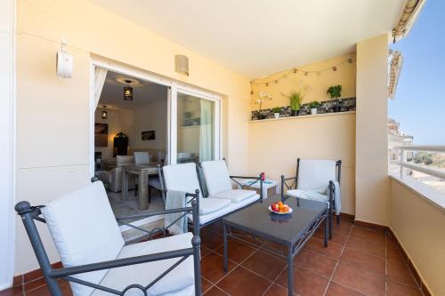 a balcony with chairs and a table and a dining room at Chill & Shine - Sun and Relax in Benalmádena