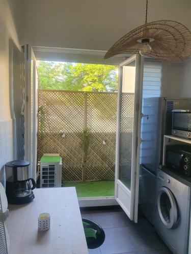 une cuisine avec une porte s'ouvrant sur une cour dans l'établissement Joli appartement Parc Chambrun, à Nice