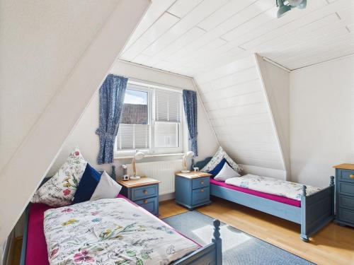 a attic bedroom with two beds and a window at Villa Rose Neu renoviert und voll ausgestattet in Königsberg in Bayern