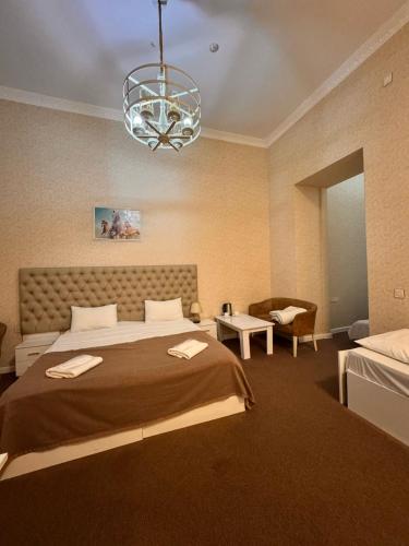 a bedroom with a large bed and a chandelier at Sahil Breeze Boutique in Baku