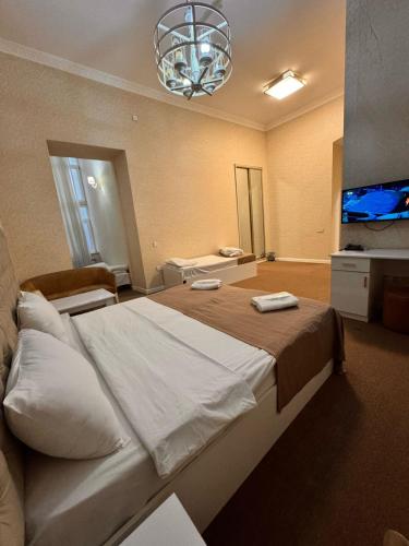 a bedroom with a large bed and a flat screen tv at Sahil Breeze Boutique in Baku