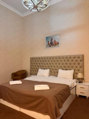 a bedroom with a large bed with two towels on it at Sahil Breeze Boutique in Baku