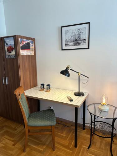 a desk with a lamp and a chair in a room at Happy8 in Gdynia
