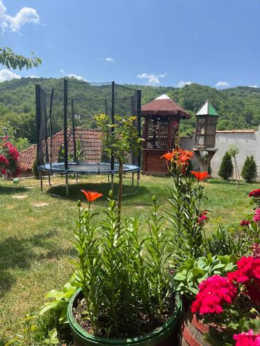 a garden with flowers and a gazebo in the background at Temački konaci in Pirot